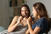 Zwei Frauen sitzen auf dem Sofa und essen Schokolade. Zwei Frauen sitzen auf dem Sofa und essen Schokolade.